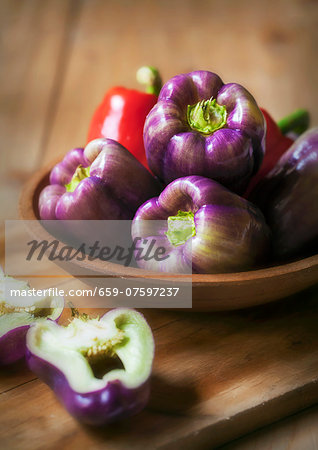 Purple and Red Bell Peppers in a Wooden Bowl Purple and Red Bell Peppers in a Wooden Bowl