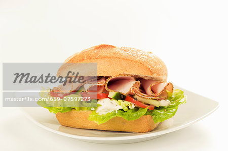 A sandwich filled with lettuce, tomatoes and sliced turkey A sandwich filled with lettuce, tomatoes and sliced turkey