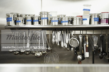 https://image1.masterfile.com/getImage/659-07597959em-professional-kitchen-hanging-tools-and-canisters-of-seasonings-stock.jpg