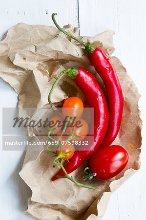 Whole chillies and tomatoes on paper Whole chillies and tomatoes on paper