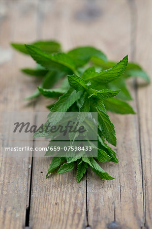 Fresh peppermint (Mentha piperita) on a wooden table Fresh peppermint (Mentha piperita) on a wooden table