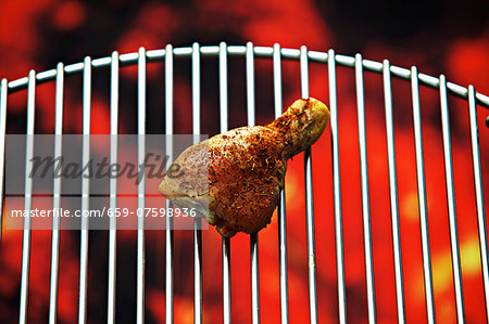A chicken drumstick on a barbecue