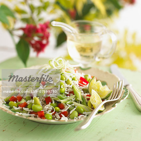 Rice salad with soy beans and lime wedges