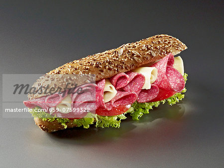 Seeded bread roll filled with salami, cheese and tomatoes Seeded bread roll filled with salami, cheese and tomatoes