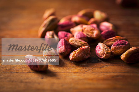 Shelled pistachios on a wooden surface