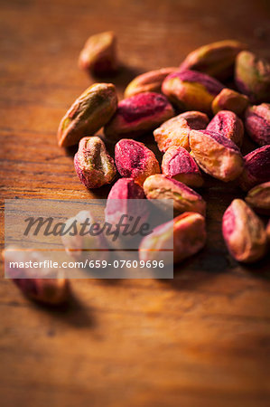 Shelled pistachios on a wooden surface