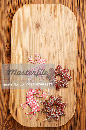Lebkuchen stars (spiced soft gingerbread from Germany) and Christmas tags on a chopping board Lebkuchen stars (spiced soft gingerbread from Germany) and Christmas tags on a chopping board