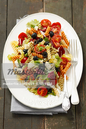 Pasta salad with olives, cherry tomatoes, iceberg lettuce and mozzarella Pasta salad with olives, cherry tomatoes, iceberg lettuce and mozzarella
