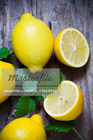 Fresh lemons and lemon balm on a wooden surface Fresh lemons and lemon balm on a wooden surface