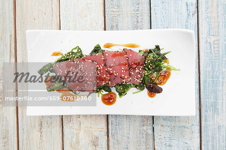 Tuna sashimi with sesame on a bed of seaweed