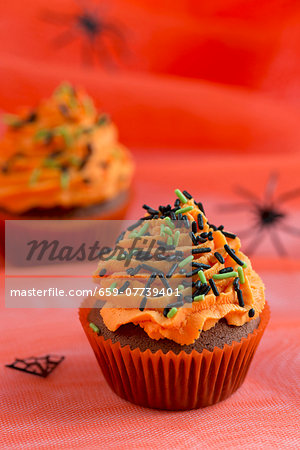 Chocolate cupcakes with orange buttercream and sugar sprinkles for Halloween