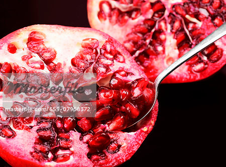 A pomegranate with a spoon