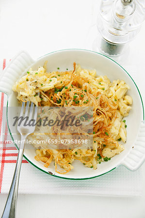 Cheese Spätzle (soft egg noodles from Swabia) with fried onions in an enamel baking dish