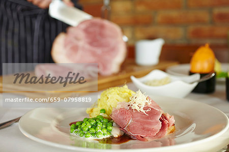 Glazed leg of ham with mashed potatoes and mint peas