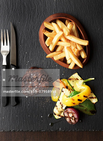 Grilled beef steak with chips and grilled vegetables