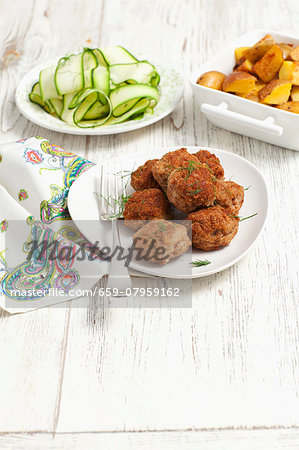 Meatballs served with a courgette salad and roast potatoes Meatballs served with a courgette salad and roast potatoes
