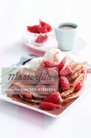 Pancakes with maple syrup, ice cream and strawberries