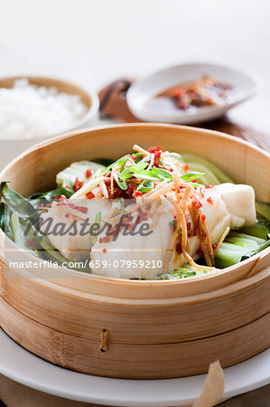 Steamed fish on a bed of bok choy with ginger and chilli