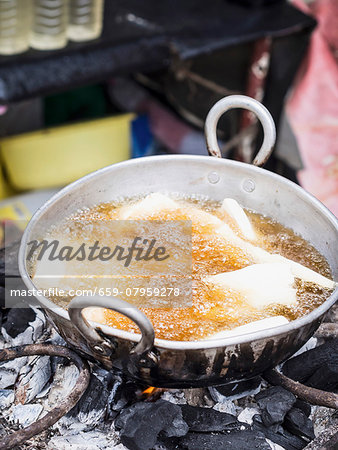 Deep-fried casava in hot oil at a local market on Zanzibar