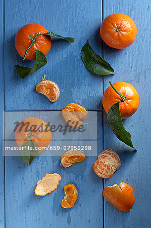 Clementines with leaves, whole and peeled