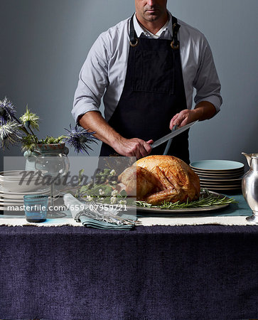 A man carving a roast turkey A man carving a roast turkey