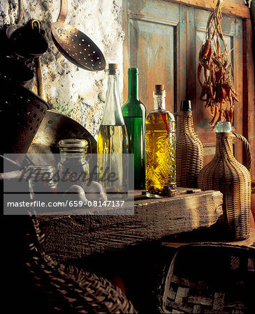 Bottles of oils, copper pots, jugs and spices in a rustic kitchen Bottles of oils, copper pots, jugs and spices in a rustic kitchen