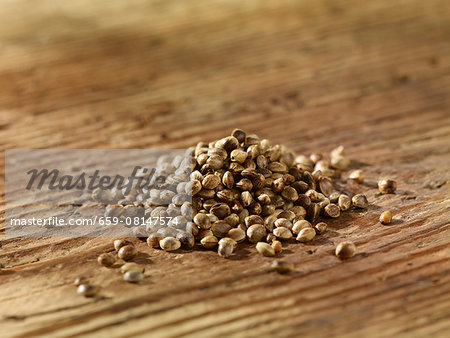 A pile of hemp seeds on a wooden surface A pile of hemp seeds on a wooden surface