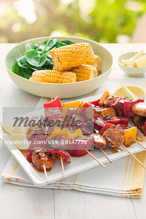 Pork skewers with peppers served with corn cobs Pork skewers with peppers served with corn cobs