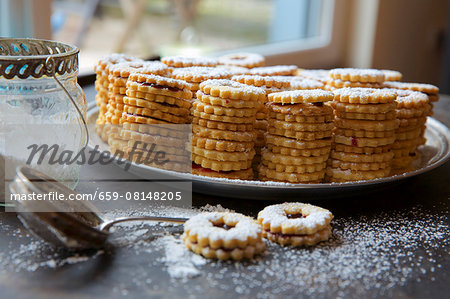Stacks of jammy shortbread biscuits with icing sugar Stacks of jammy shortbread biscuits with icing sugar