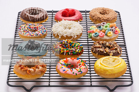 Various colourful doughnuts on a wire rack