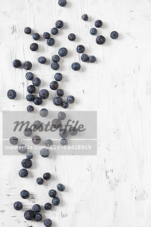 Blueberries scattered on a white surface