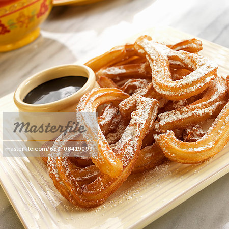 Churros with icing sugar and dark chocolate sauce (Mexico)