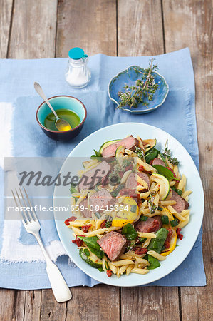 Penne pasta salad with roast beef, courgettes, dried tomatoes and spinach