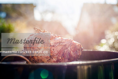 A knuckle of lamb on a barbecue