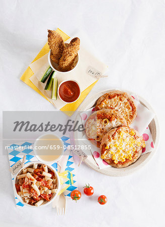 Various children's dishes: mini pizzas, pasta with tomatoes and chicken nuggets