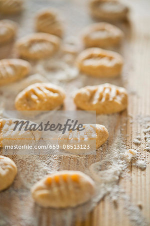 Gnocchi with flour on a wooden board