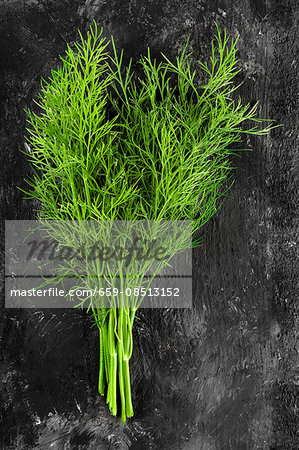 A bunch of fresh dill on a dark surface