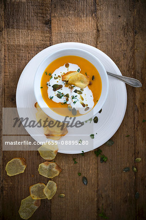 Vegan pumpkin soup with soya cream and potato chips