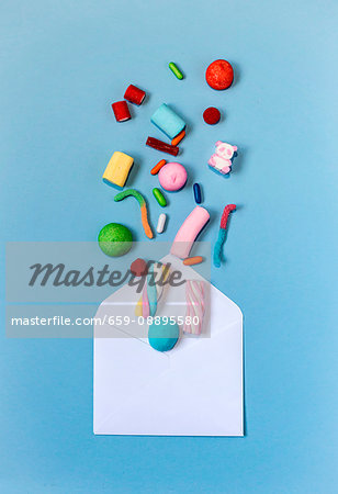 Colourful sweets coming out of an envelope on a light-blue background