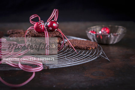 Christmas chocolate and walnut cookies wrapped in gift ribbon with a bauble decoration