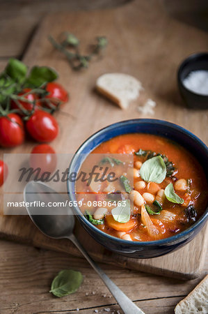 Tuscan ribollita soup with beans, tomatos, kale and basil in a bowl Tuscan ribollita soup with beans, tomatos, kale and basil in a bowl