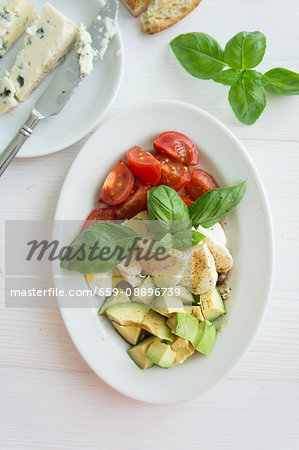 Tomatoes, mozzarella and avocado with basil