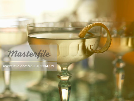 A cocktail with lemon peel