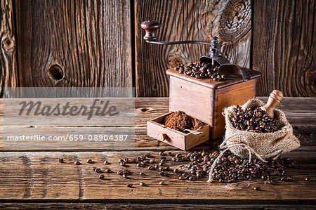 A sack of coffee beans and an old coffee grinder