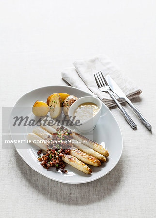 White asparagus with fried diced bacon, chives, Hollandaise sauce and potatoes