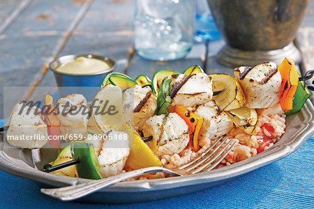 Grilled halibut kebabs with pepper and lemon wedges on a bed of rice Grilled halibut kebabs with pepper and lemon wedges on a bed of rice