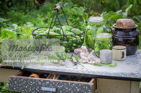 Freshly pickled gherkins in preserving jars on a garden table