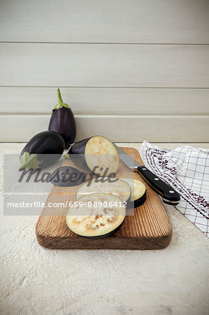 Aubergine sliced into round disks on a chopping board