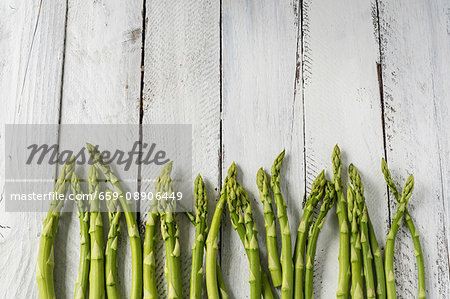 Green asparagus on white wood