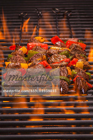 Beef skewers with peppers on a flaming grill Beef skewers with peppers on a flaming grill